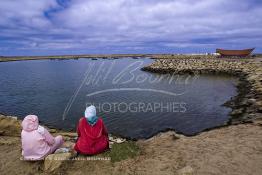 Image du Maroc Professionnelle de  Deux femmes sont assises au bord de la rive du port de pêche d'Asilah, Vue du front de mer d’Asilah ville au nord-ouest du Maroc à 40 km au sud de Tanger, ancienne fortification Portugaise  construite XVIe siècle , Dimanche 9 Septembre 2001. (Photo / Abdeljalil Bounhar)





